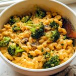A bowl of creamy Healthy One Pot Broccoli Mac & Cheese with florets of broccoli and mushrooms.