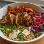 A delicious Hot Honey Chicken Bowl featuring grilled chicken, roasted sweet potatoes, quinoa, and red cabbage slaw.