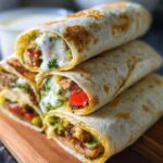 Stack of Juicy Garlic Parmesan Chicken Meatloaf wraps filled with chicken, vegetables, and sauce.