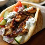 A delicious Mediterranean Chicken Gyro packed with seasoned chicken, fresh tomatoes, cucumber, red onion, and creamy feta tzatziki sauce.