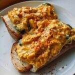 Close-up of spicy buffalo chicken filling piled high on two slices of toasted bread for Spicy Buffalo Chicken Wraps for Two.