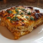 A slice of Creamy Low Carb Chicken Casserole topped with melted cheese and fresh parsley.