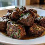 A close-up of tender High Protein Slow Cooker Garlic Butter Beef Bites, glistening with sauce and sprinkled with parsley.
