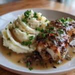 A close-up of Irresistible Garlic Herb Chicken served with a swirl of creamy mashed potatoes, garnished with fresh parsley.