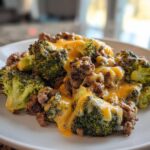 A close-up of a serving of Keto Hamburger Broccoli Skillet, featuring ground beef and broccoli covered in melted cheddar cheese.