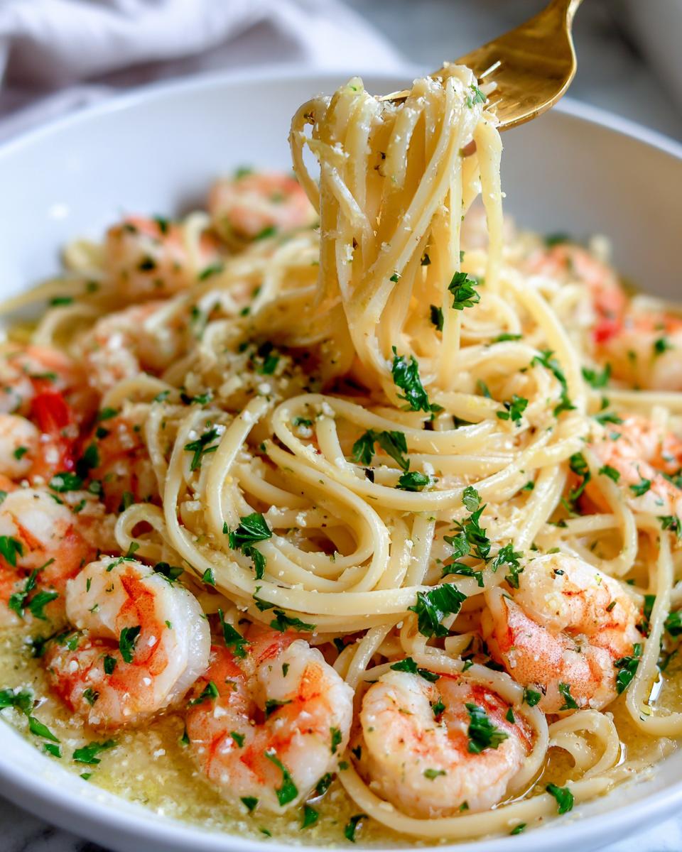 A fork twirls pasta with shrimp and parsley, showcasing a delicious Lemon Shrimp Linguine.