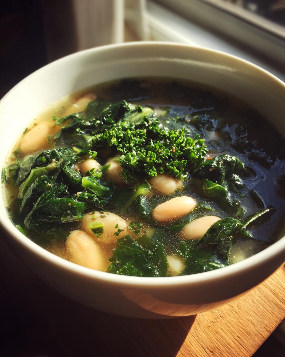 A bowl of hearty white bean kale soup, garnished with fresh parsley, perfect for healthy comfort.